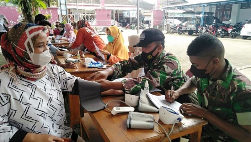 Anggota Koramil Membantu Tenaga Kesehatan Berikan Pelayanan Kepada Warga